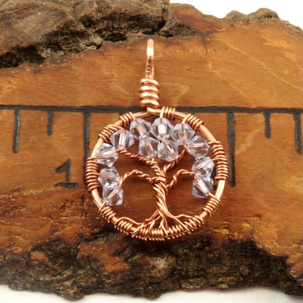 An image of the June birthstone tree of life pendant from Uncorked & Bottled Up on a ruler showing the size of the pendant