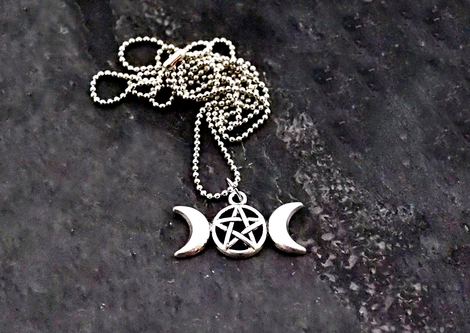 A close up image of the triple goddess pentagram necklace from Uncorked & Bottled Up