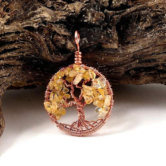 A product image of the November birthstone tree of life pendant from Uncorked & Bottled Up made with genuine citrine gemstones and copper wire against a wood background